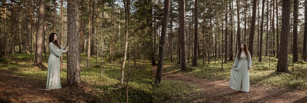Nainen seisoo metsässä kauniissa boho-mekossa.